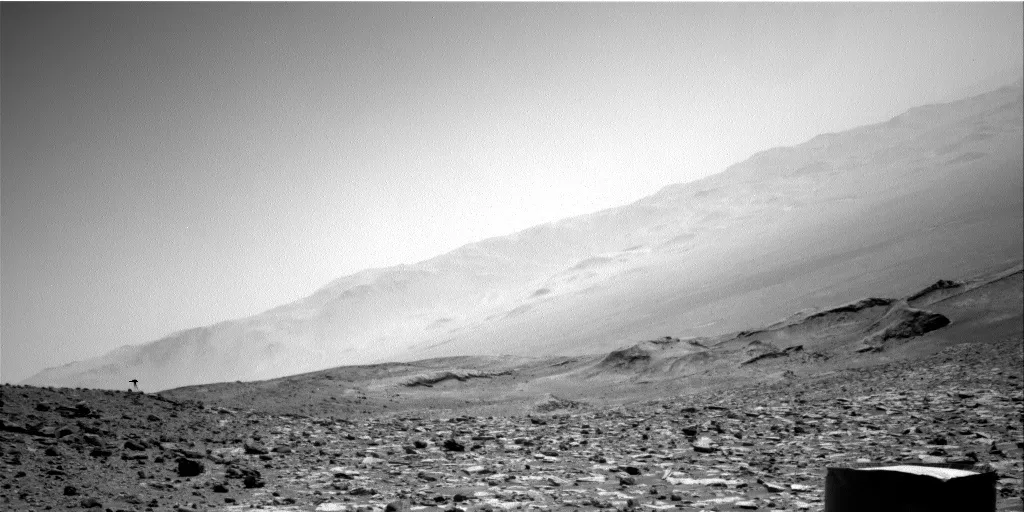 Sirova fotografija iz desne navigacione kamere rovera Curiosity, Sol 3924 (20. august 2023.), s tamnom siluetom u lijevom dijelu kadra